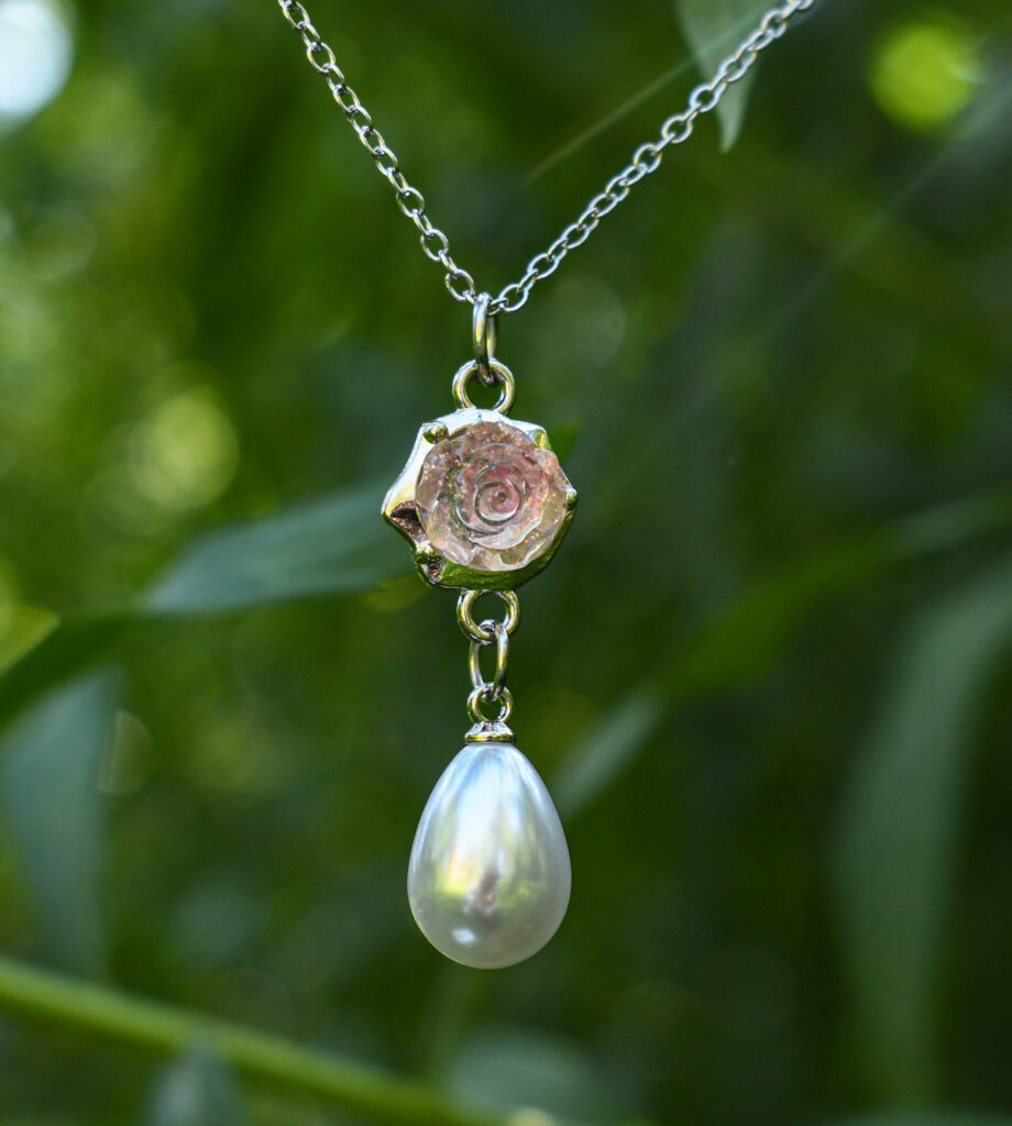 Roosa läikiva roosiõie ja pärliga kaelakee